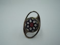 A silver ring by Caithness glass having a millefiori glass panel in a stylised oval mount, size