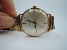A gents 9ct gold wrist watch by Mondia having a baton numeral dial to silvered face in a 9ct gold