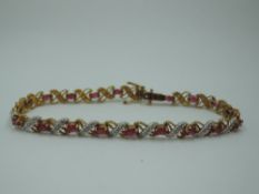 A 9ct gold articulated bracelet having rubies interspersed by diamond chip set two coloured