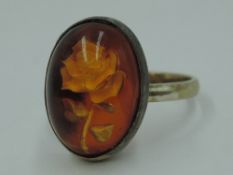 A lady's dress ring having a rose intaglio cabouchon panel in a yellow metal collared mount and