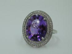 An oval facet cut heat treated amethyst ring having a diamond chip double border in a pave setting