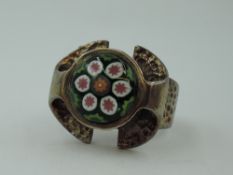 A silver ring by Caithness glass having a millefiori glass panel in a stylised mount, maker CJ, size