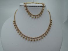 A 9ct gold necklace and matching bracelet having ball and dot decoration on belcher link chain,