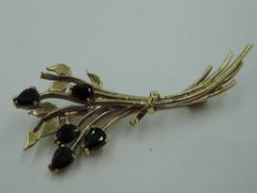 A 9ct gold and sapphire brooch in the form of a tied bunch of flowers, approx 3.3g