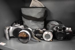 A selection of cameras including a Canon EOS300 with Canon EF28-90mm lens, a Lumix DMC TZ3 digital