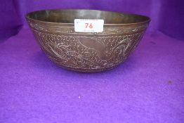 A brass singing bowl having cast Chinese characters to bottom and chased design of dragons and