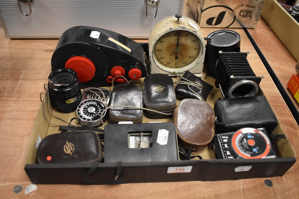 A box of photographic equipment, including light meters, darkroom clock, candid angle lens etc