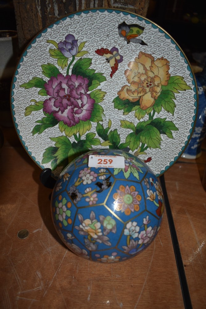 A cloisonne carpet or similar ball and a plate decorated with plants and butterfly