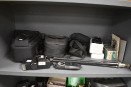 A selection of camera equipment including camera bags, light meter, tripod, flash shoe etc