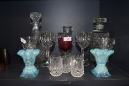 A selection of glasses and two decanters also included are two blue vaseline glass candle sticks.