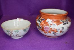 An iron red ground Japanese bowl and similar Canton styled porcelain bowl