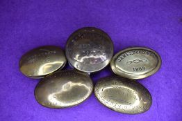 Five brass cast snuff box or containers including North Devon Bedwas and Barnes