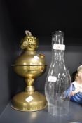 A vintage brass oil lamp having glass chimney.