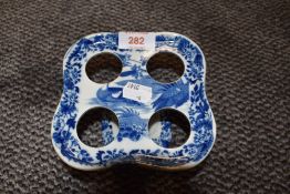 An early transfer printed breakfast egg holder in blue and white ceramic having a tin glaze