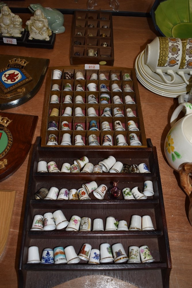 A collection of vintage and souvenir thimbles and wooden display cases.
