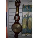 A large antique banjo barometer having mirror and inlaid detailing and scrolled finials to top.