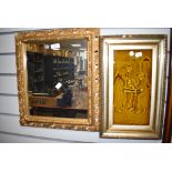 A gilt and gesso framed hall way mirror and ceramic relief wall tile of priest and parson smoking