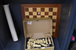 A wooden chess board and a collection of large novelty pieces.