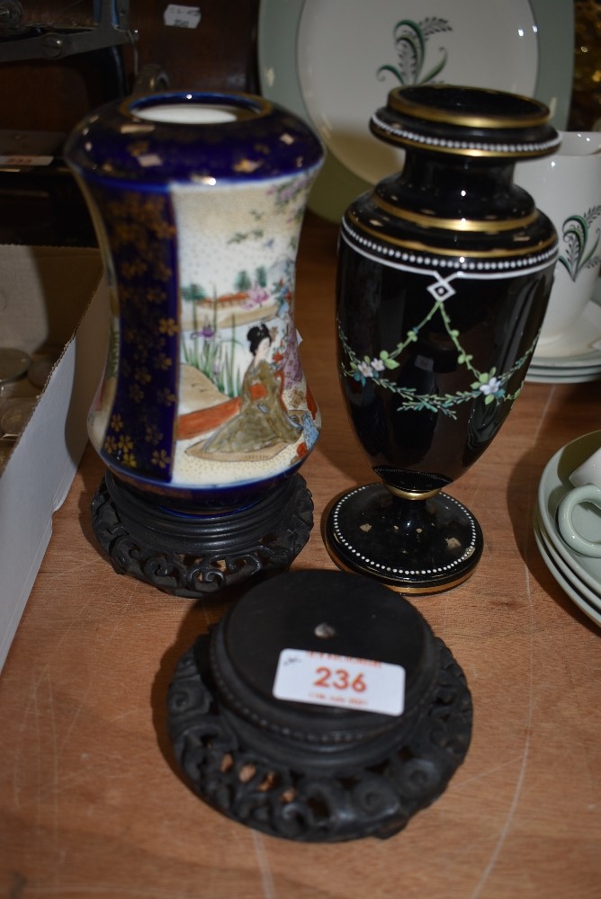 An antique black glass vase with floral swag detail in enamel and a Satsuma vase with gilt detailing