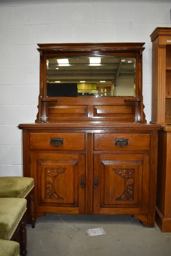 An Art Nouveau oak dresser side board having original handles and mirror back