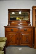 An Art Nouveau oak dresser side board having original handles and mirror back