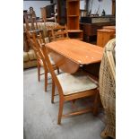 A modern mid century designed dining set by Ercol four ladder back chairs and matching circular