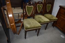 A set of three late Victorian carved frame dining chairs with green satin upholstery