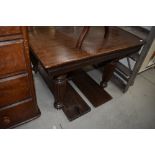 A late Victorian oak windout dining table having fluted legs, winder and four additional leaves