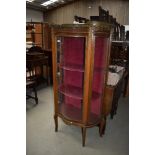 A regency styled continental display case having ormalu details with glass frontage and velvet