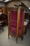 A regency styled continental display case having ormalu details with glass frontage and velvet