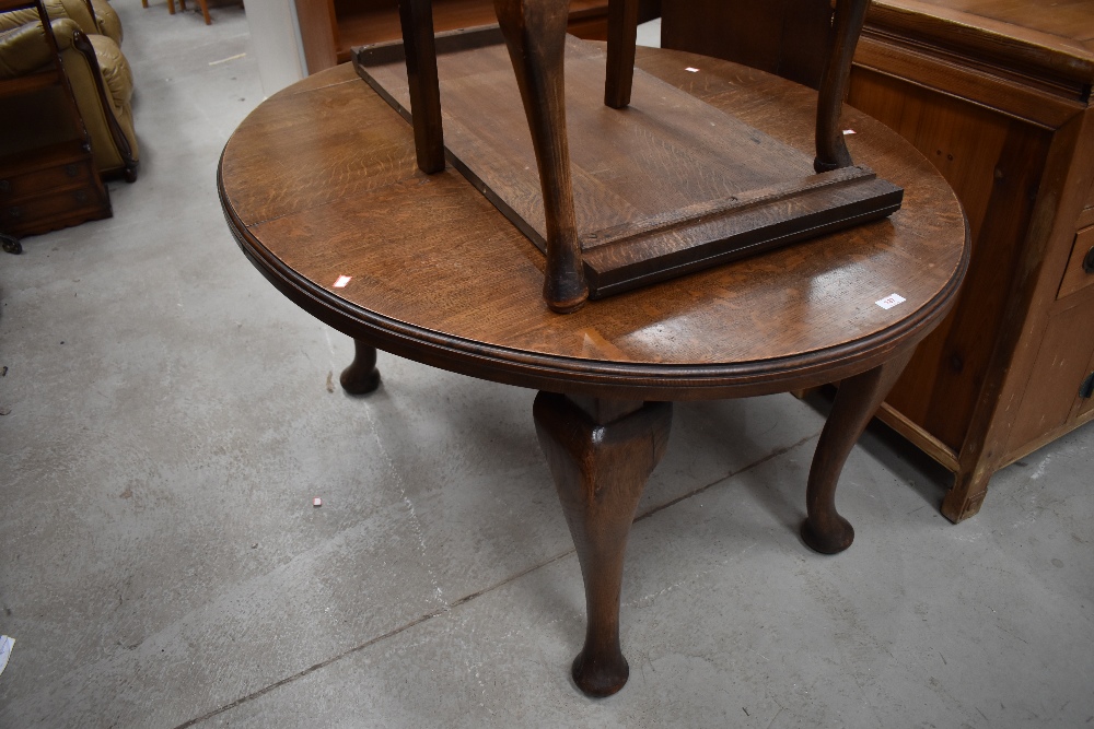 An oval oak dining table late Victorian having large carved legs and additional extendable leaf