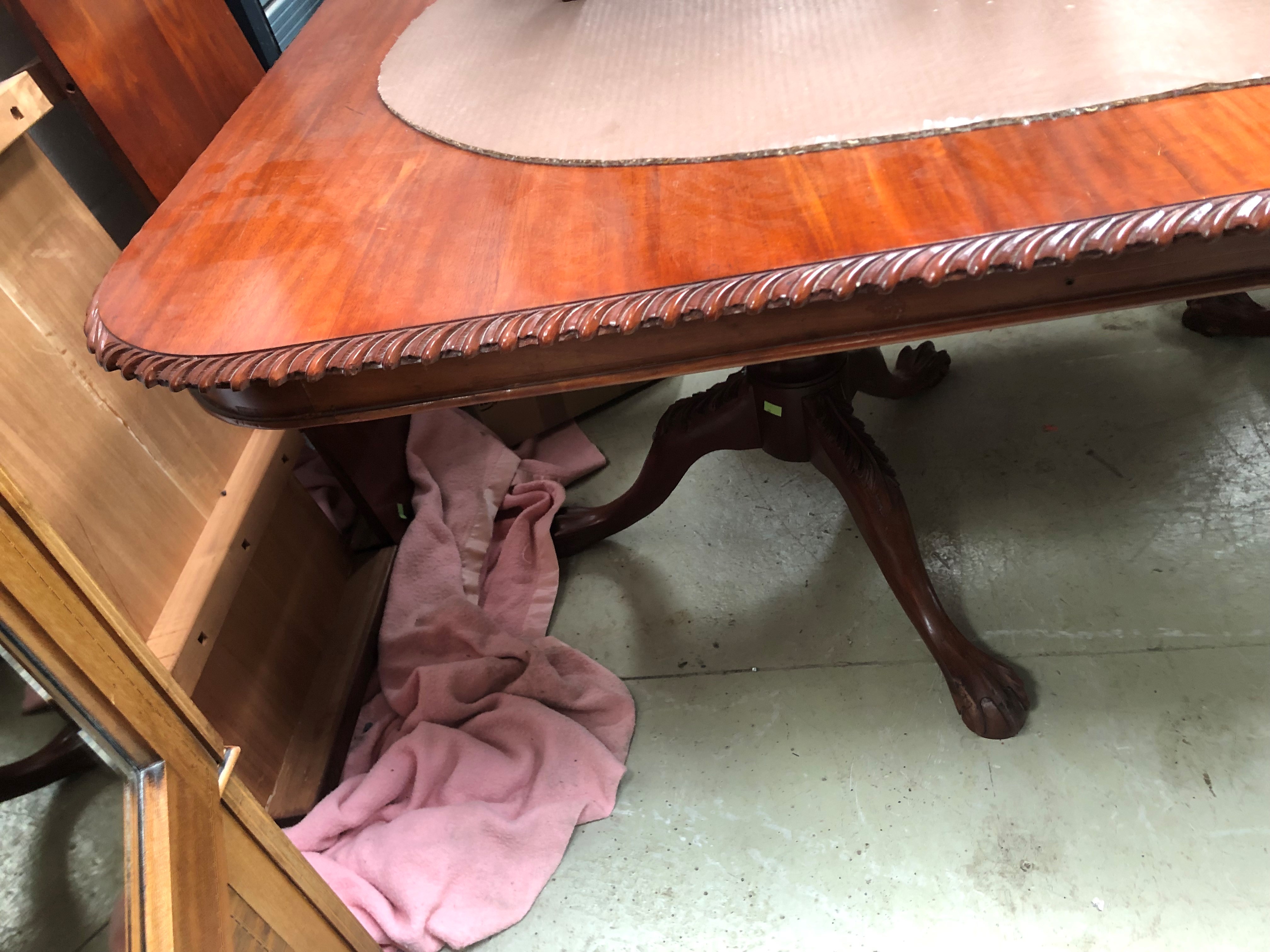 A reproduction banquetting table in the 19th Century style, having gadrooned edge, ball and claw