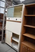 A mid century kitchen storage cabinet or larder by Hollins with original glass interior