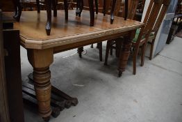 A 19th Century oak dining table, on turned legs , having wind out mechanism and additional legs