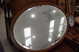 An Edwardian mahogany and inlaid oval wall mirror, width max approx. 90cm
