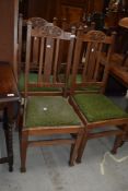 A set of four early 20th Century golden oak highback dining chairs having drop in seats