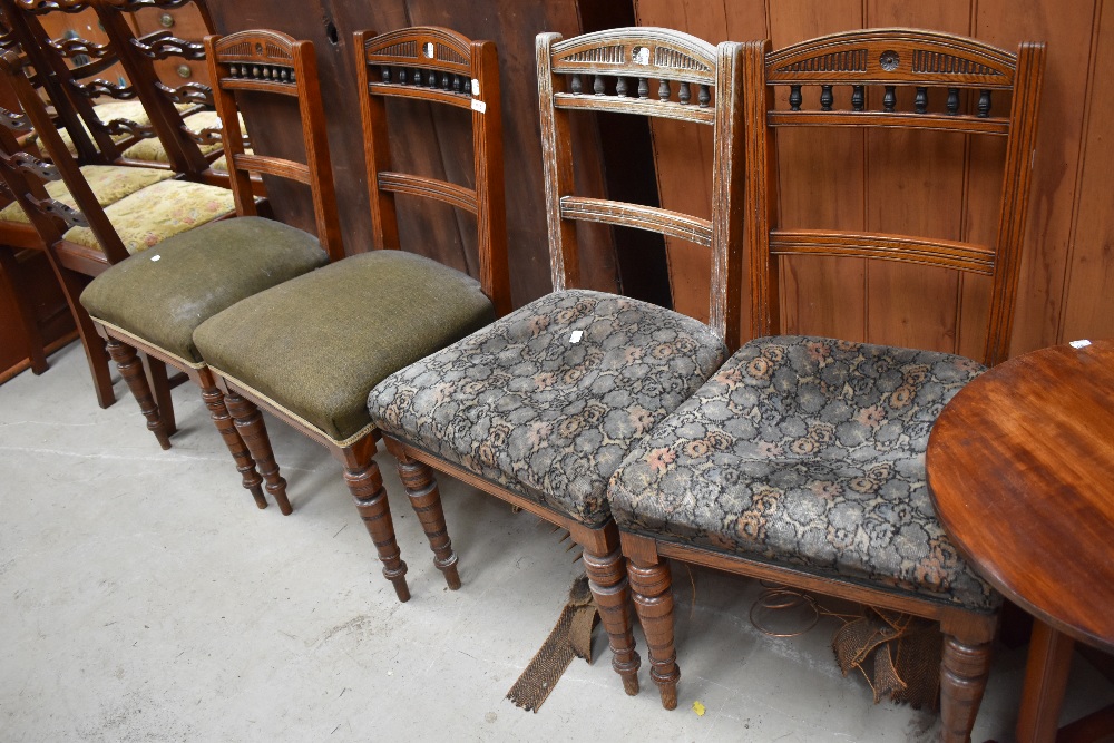A set of four 19th Century oak railback dining chairs having overstuffed seats and turned legs,