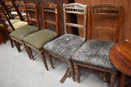 A set of four 19th Century oak railback dining chairs having overstuffed seats and turned legs,