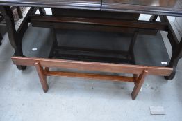 A vintage stained frame coffee table having smoked glass top