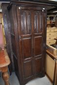 An early 20th Century oak hall robe/wardrobe in the monastery style with panelled door having