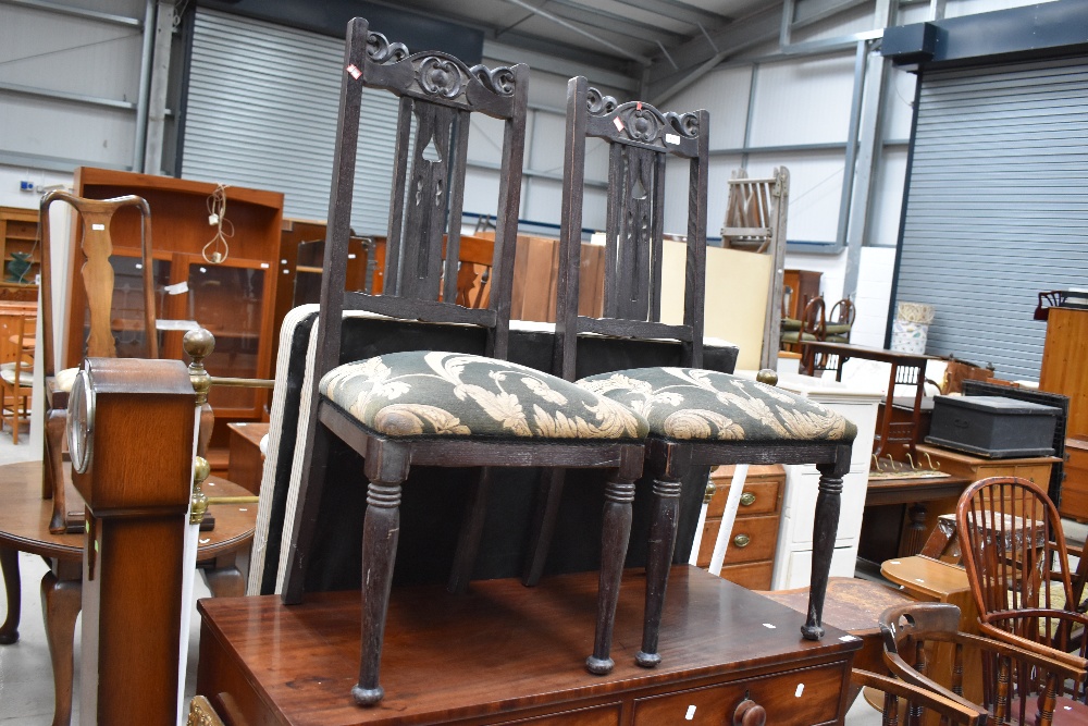 A pair of late 19th dark stained dining chairs with overstuffed seats having later upholstery,
