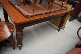 A 19th Century mahogany wind out dining table in the Gillows style, having heavy turned and fluted