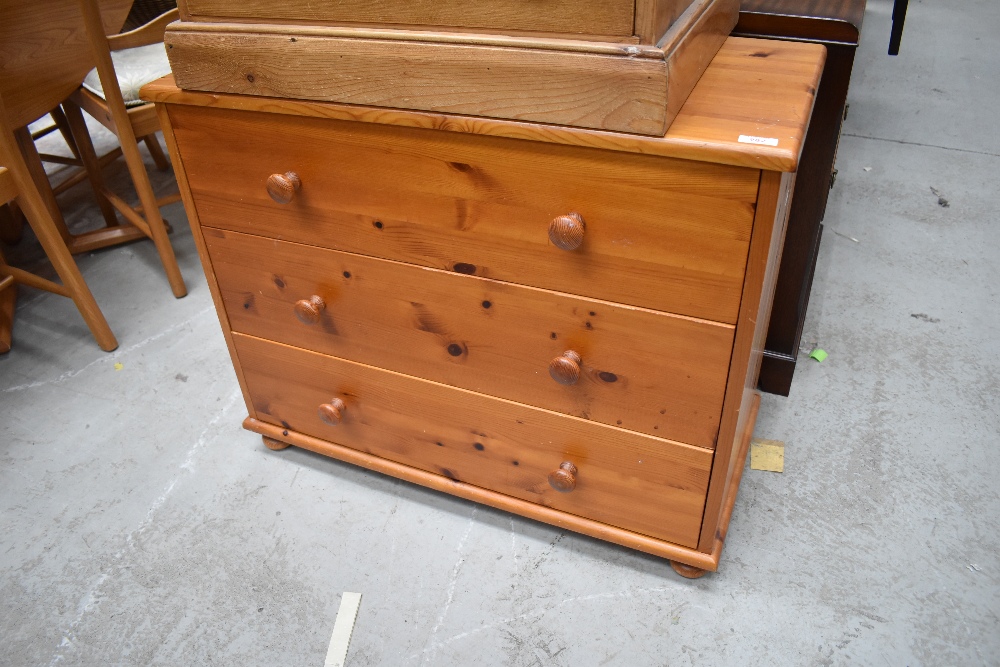 A chest of three pine drawers with matching handles