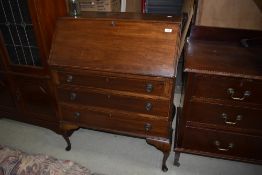 A reproduction mahogany bureau having three drawer set