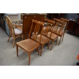 A set of four modern beech wood kitchen chairs with rail back