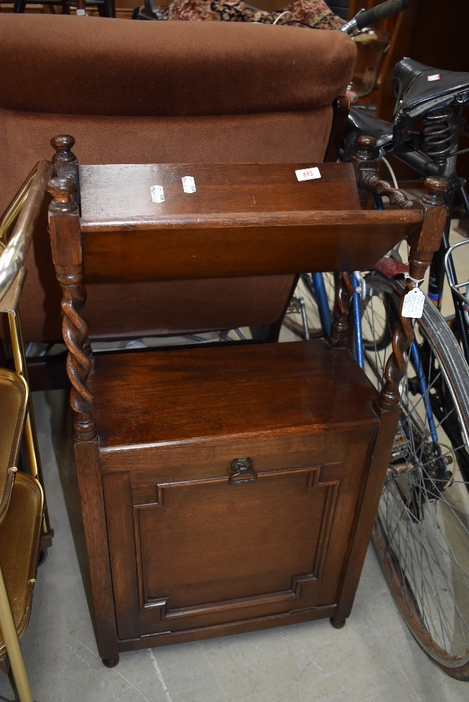 An early 20th Century oak bookstand with sheet music/magazine compartment