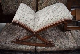 An antique rocking foot or gout stool having fluted frame and upholstered seat