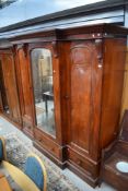 A 19th Century mahogany breakfront mirror door wardrobe , fitted drawer centre section ad drawer