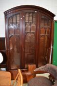A large three part display or book case having Gothic design arched door frames