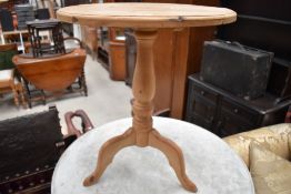 A natural pine pedestal table having circular top, turned pedestal and triple splay legs, diameter